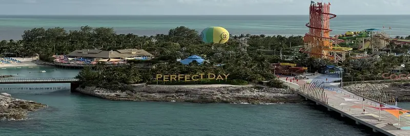 The Perfect Day sign, the balloon and the waterpark towers at Perfect Day at CocoCay from the pier