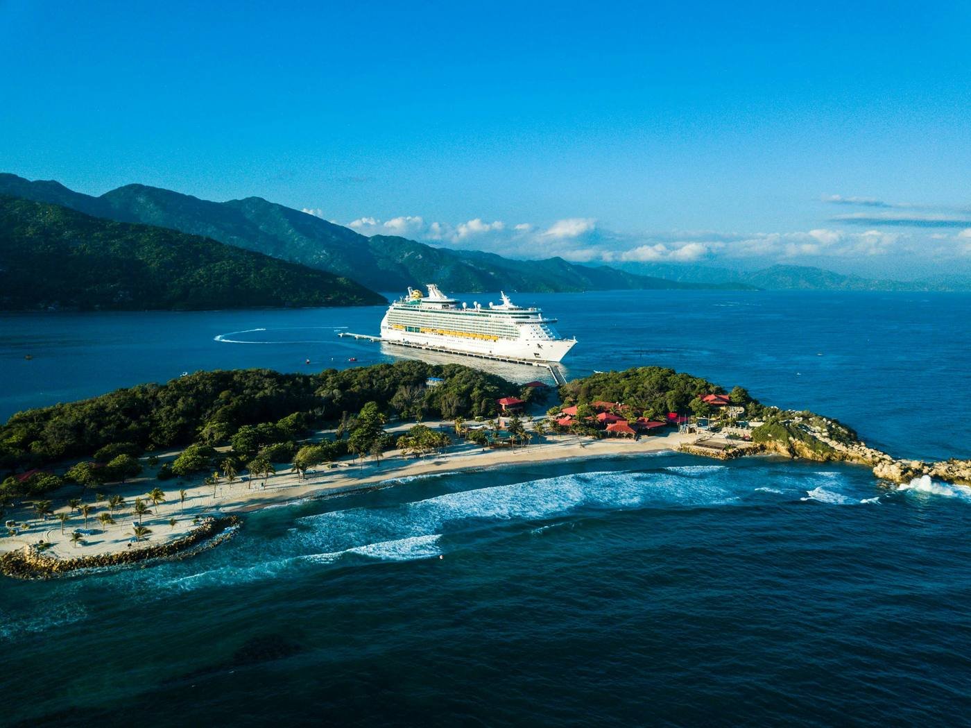 Royal Caribbean cruise ship docked at a Caribbean island aerial view